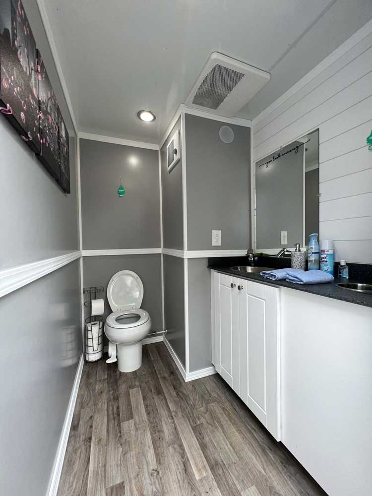 Luxury restroom trailer interior with hardwood floors and vanity